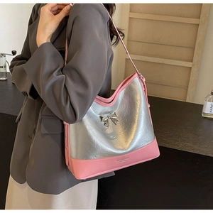 Detail of silver metallic bow and pink leather texture on a stylish underarm tote bag