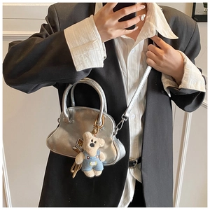 Detalle de bolso nube plateado metalizado con pliegues y colgante de osito azul