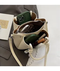 Interior view of off-white bucket bag showing three spacious compartments and storage