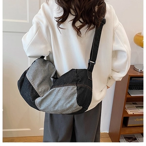 Detail view of large denim patchwork crossbody bag showing contrast stitching and soft drape