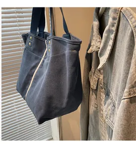 Detail of dark blue canvas tote bag with side stripes and metallic rivet fastening