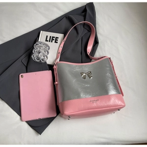 Detail of silver metallic pleats and pink leather texture on underarm bag with bow