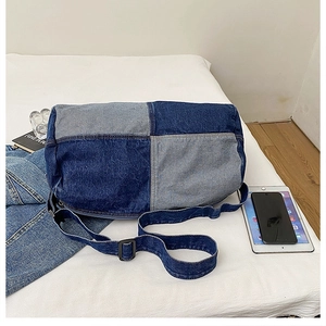 Detail view of the blue patchwork denim crossbody tote bag in a casual lifestyle setting