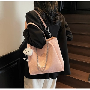 Close-up of pink snakeskin pattern tote bag with pearl chain and cloud charm