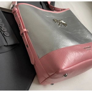 Detail of pink and silver patchwork tote bag with bow buckle and metallic rivet strap