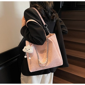 Detail of pink snake-pattern tote bag with decorative pearl chain and cloud pendant