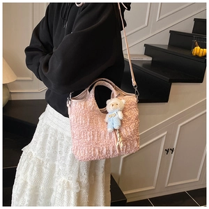 Sac fourre-tout rose à texture bulles avec breloque ours porté par un mannequin
