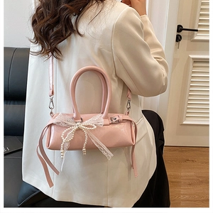 Dettaglio della borsa a cilindro rosa con fiocco in pizzo e decorazioni di perle