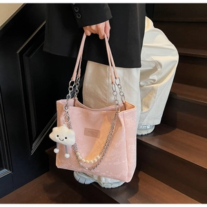 Detail of pink snake-pattern tote bag with silver chain handle and pearl strap detail