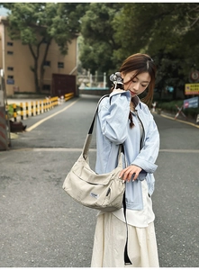 Close-up of beige nylon crossbody bag with adjustable strap and tactical flap design