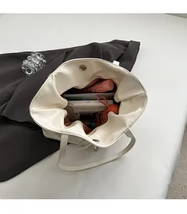 Intérieur spacieux du sac cabas blanc en similicuir avec fermeture magnétique et objets
