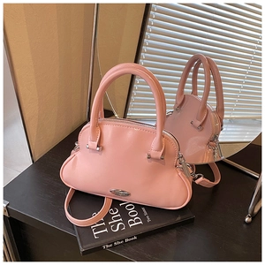 Detalle de bolso rosa brillante con base plisada tipo nube y herrajes plateados finos