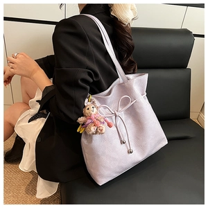 Détail du sac cabas lilas avec nœud décoratif et breloque ours en peluche