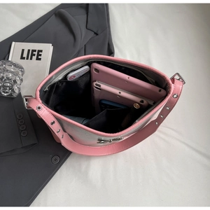 Top view of spacious interior of pink bow shoulder bag holding a tablet and phone