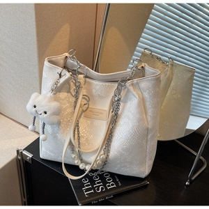 Close-up of white animal texture tote with silver chains and plush cloud charm