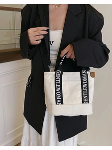 Chic off-white canvas tote bag with GENTLEWOMAN letter straps held by a model