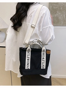 Minimalist black canvas tote bag with GENTLEWOMAN handles shown from a back perspective