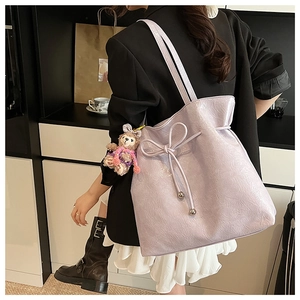 Détail du sac cabas lilas avec nœud de serrage et charmant petit ours en peluche
