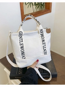 White canvas Gentlewoman tote bag with black lettering and leather trim detail