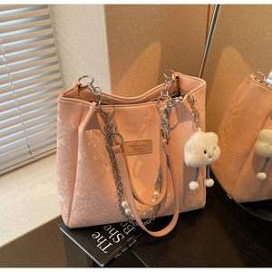 Detail of pink snake-pattern tote bag with silver chain pearls and plush cloud charm