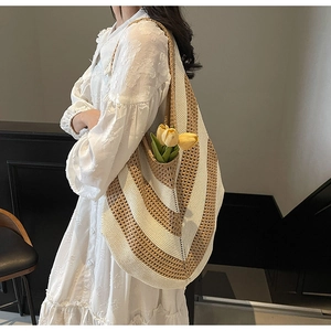 Close-up of beige and khaki striped knit tote bag with shoulder strap for beach