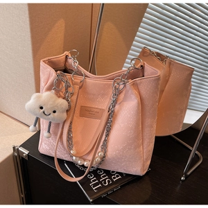 Detailed shot of pink snake embossed tote with pearl chain and cloud plush charm