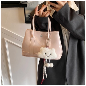 Pink patent leather tote with round metal logo and a cute plush cloud charm