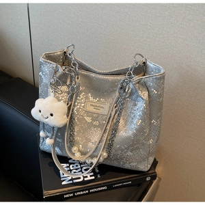 Detail of silver snake-embossed tote bag with pearl chain and cloud charm