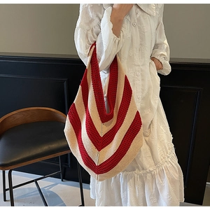 Detail of red and cream striped knitted tote bag featuring a textured crochet weave design