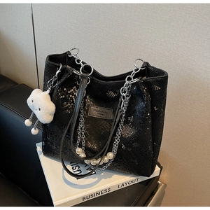 Close-up of black snake pattern tote bag with metal chain and pearl handle detail