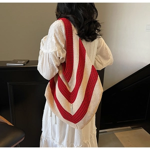 Detail of red and white striped knit tote bag showing the textured V-shape weave pattern