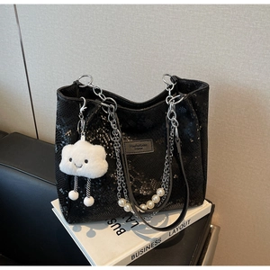 Detail of black snakeskin tote bag with silver chain strap and pearl cloud charm