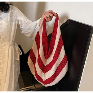 Close-up of red and beige striped knit shoulder bag with handmade crochet texture
