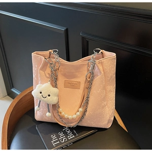 Pink tote bag detail with snake pattern, pearl chain strap and cloud plush pendant