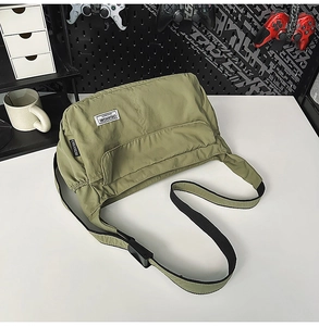 Detail view of olive green nylon crossbody bag with textured fabric and adjustable strap