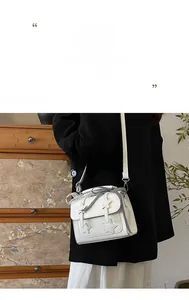 Detailed shot of white PU leather crossbody bag with star patch and lace trim detail