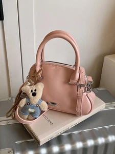Bolso estilo concha rosa claro para mujer con colgante de oso y detalles plateados