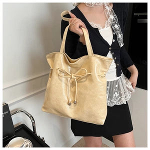 Détail du grand sac cabas crème avec nœud coulissant et perles métalliques argentées