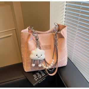 Detailed close-up of pink snake-embossed tote bag with silver chain and pearl strap