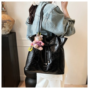 Détail du cabas noir verni avec cordon à nœud et pendentif lapin en peluche mignon