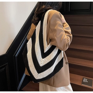 Detail of black and white V-stripe knit tote bag with textured crochet pattern