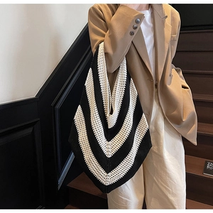 Macro detail of black and white striped knit tote bag showing intricate hand-woven texture