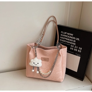 Detail of pink tote bag with snake texture, pearl chain and plush cloud charm