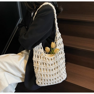 Detalle de bolso de hombro de ganchillo blanco con forro de cordón y decoración de tulipán