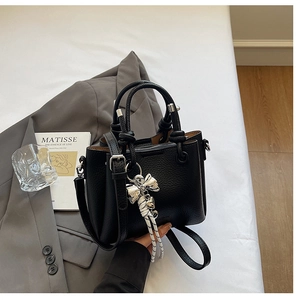 Detail of black lychee grain bucket bag featuring silver hardware and a knotted handle