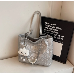 Detail of silver snake-pattern tote bag with pearl chain and white plush charm