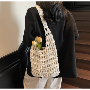 Detalle de bolso saco beige tejido a mano con cordón ajustable y correa ancha al hombro