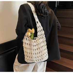 Detalle del bolso tote de malla hueca tejido a mano en beige con detalle de tulipán