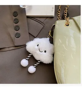 Close-up of white plush cloud charm with embroidery on green chain shoulder bag