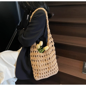 Detalle del bolso de paja beige tejido a mano con bandolera y tulipanes amarillos